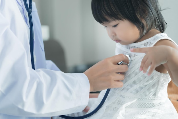 Asian doctor using a stethoscope to check his breathing and heart of a lovely girl check the health of childrenThailand people