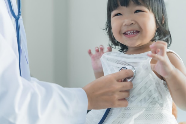 Asian doctor using a stethoscope to check his breathing and heart of a lovely girl check the health of childrenThailand people