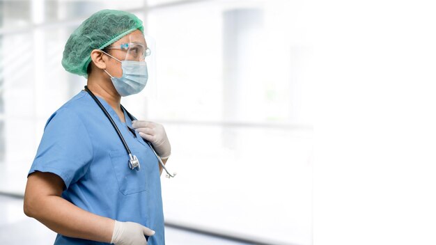 Asian doctor wearing face shield and PPE suit new normal to check patient protect safety infection Covid-19 Coronavirus outbreak at quarantine nursing hospital ward.