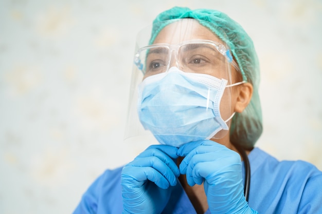 Asian doctor wearing face shield and PPE suit to protect Covid-19 Coronavirus.