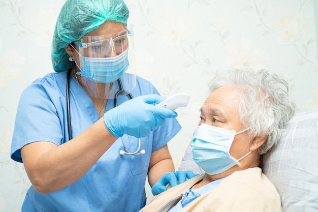 Asian doctor wearing face shield and PPE suit for protect safety infection Covid-19 Coronavirus.