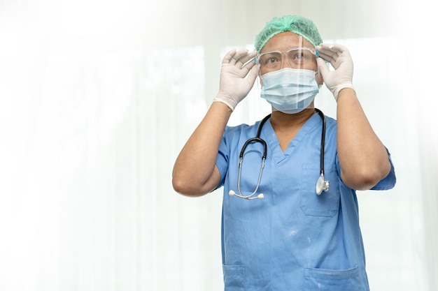 Asian doctor wearing mask face shield and PPE suit new normal isolated on white background with clipping path to protect safety infection Covid19 Coronavirus