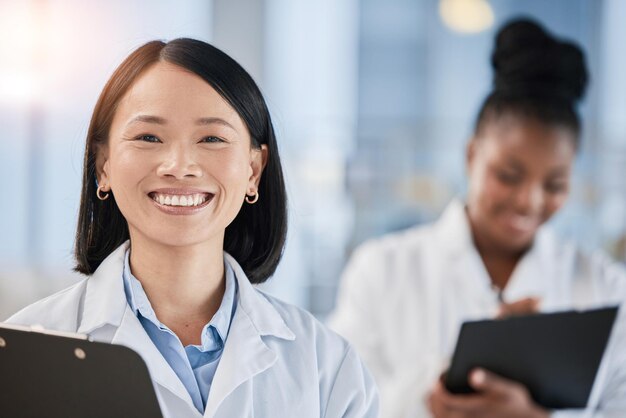 Photo asian doctor woman checklist and portrait with smile planning or happy at clinic with african expert medic teamwork and clipboard for schedule analysis or results in hospital for healthcare goal