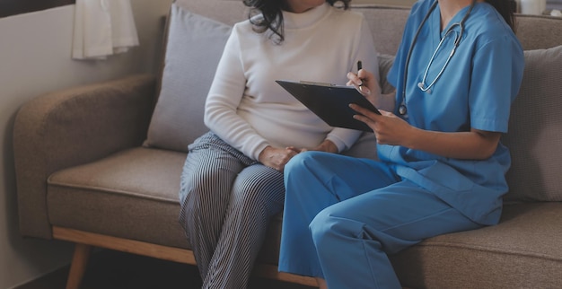 Asian doctor woman visited patient woman to diagnosis and check up health at home or private hospital Female patient explain health problem and symptoms to doctor Health care premium service at home