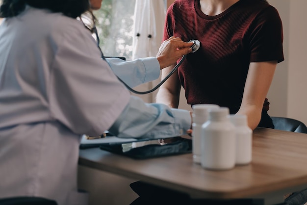 Asian doctor woman visited patient woman to diagnosis and check up health at home or private hospital Female patient explain health problem and symptoms to doctor Health care premium service at home