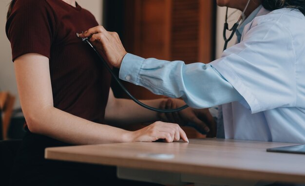 Asian doctor woman visited patient woman to diagnosis and check up health at home or private hospital Female patient explain health problem and symptoms to doctor Health care premium service at home