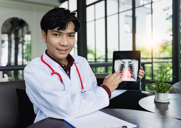 Photo asian doctors are using tablets to explain about body disorders via video call. a new normal of medical can treat follow up illnesses and consult remote patients in online  medical and remote concept