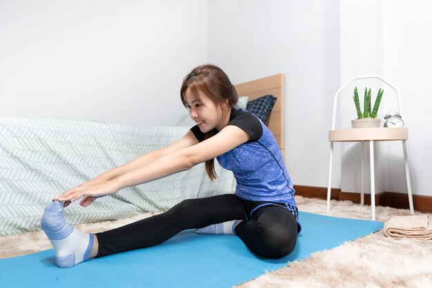 Asian doing home fitness and yoga on a fitness mat doing exercise