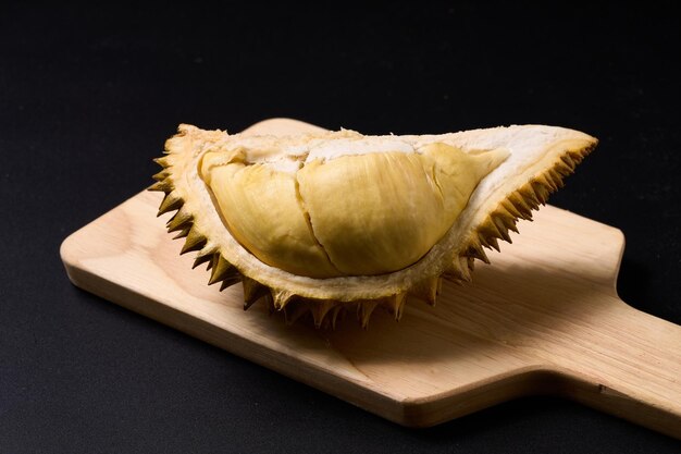 Asian durian fruit rich in natural nutrients A durian on a cutting board with a black background