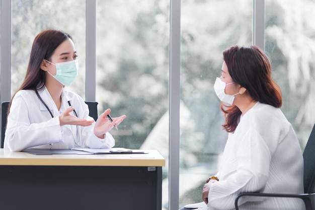 Asian elder female consults with doctor about her symptom or health problem in examination room