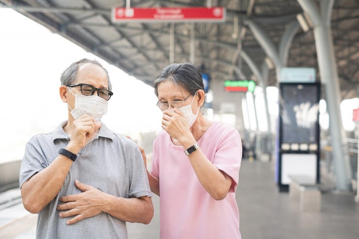 駅でのCovid-19またはコロナウイルス感染を防ぐためのマスクを身に着けているアジアの高齢者の老夫婦。