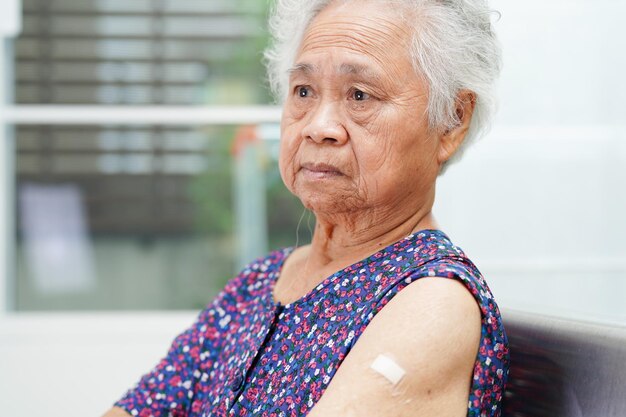 코로나 바이러스로부터 보호받기 위해 백신을 접종하는 아시아의 노인 여성