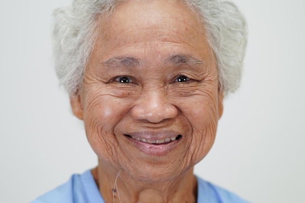 Asian elder senior woman patient sitting and smile face with happy on bed in hospital