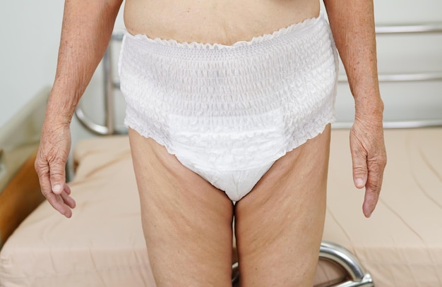 Asian elder senior woman patient wearing adult incontinence diaper pad in hospital