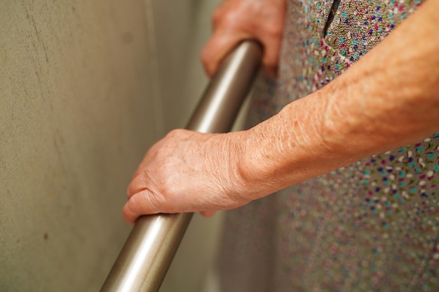 Asian elderly old woman patient use toilet support rail in bathroom handrail safety grab bar security in nursing hospital