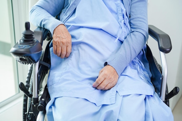 Asian elderly woman disability patient walk with walker in nursing hospital medical concept