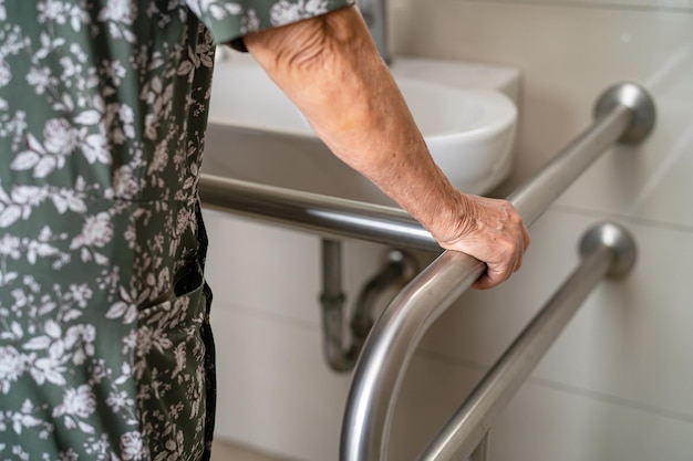 Asian elderly woman patient use toilet bathroom handle security in nursing hospital healthy strong medical concept