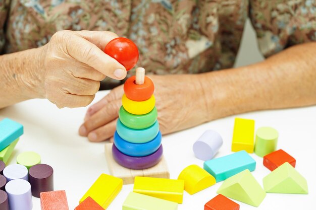 Asian elderly woman playing puzzles game for treatment dementia prevention and Alzheimer disease