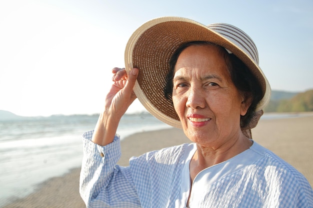 Donna anziana asiatica sorriso felice di venire al mare turismo pensionistico assicurazione sanitaria società anziana in età pensionabile