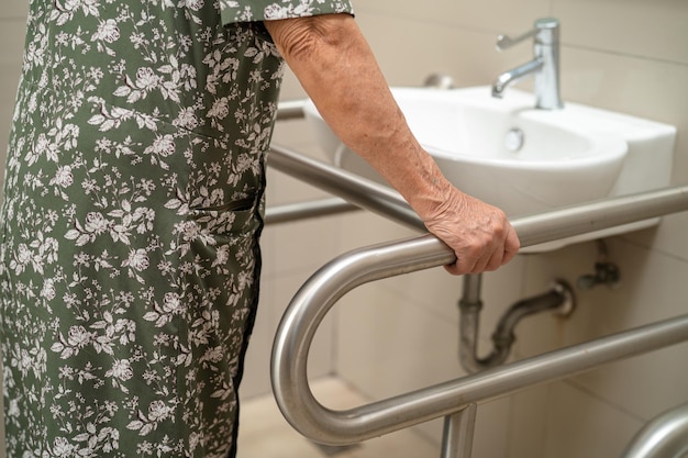 Asian elderly woman use toilet bathroom handle security healthy strong medical concept