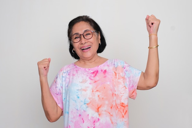 Photo asian elderly women cheering happily with both hand clenched in the air