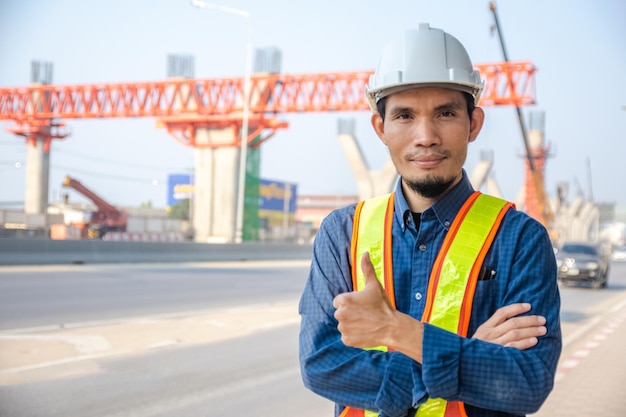 La costruzione di ingegneri asiatici è un lavoratore dipendente che lavora con un casco di controllo di sicurezza in loco