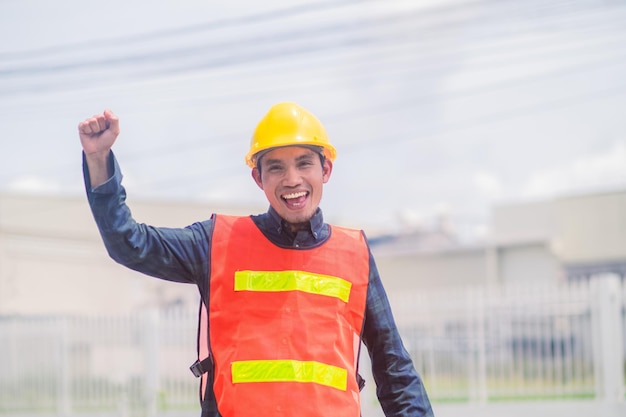 Asian engineer construction confident on site building and\
survey civil architect by contractor business with safety helmet\
factory background