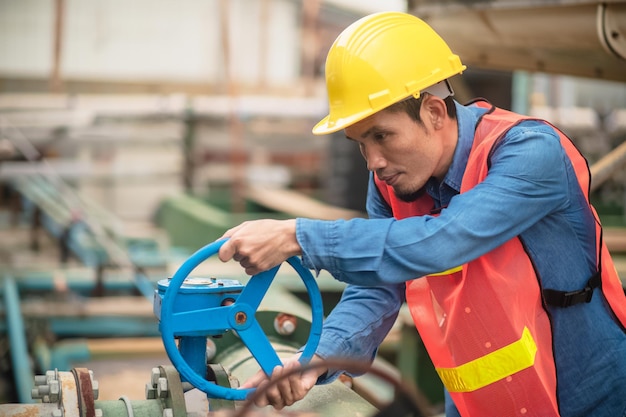 Ingegnere asiatico dipendente indonesiano lavoratore che lavora in una fabbrica di metalli pesanti tecnico operaio filippine in asia che controlla la macchina di manutenzione nella produzione industriale