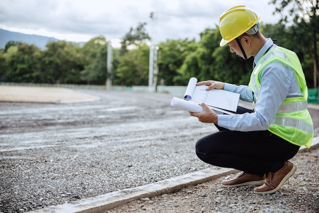 Asian engineer looking on blue printed and building structure, Worker get social security and insurance, Labor day and success business concept.