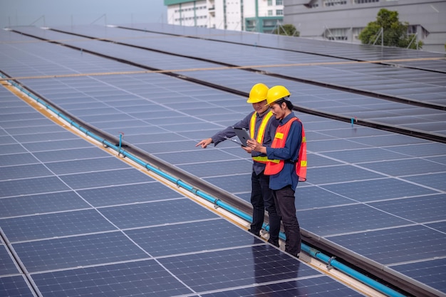 Asian engineer teamwork success standing happy in job working install on rooftop factory solar power solar cell energy