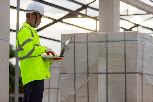 Asian engineer technician watching construction control in the construction of roof structures on construction