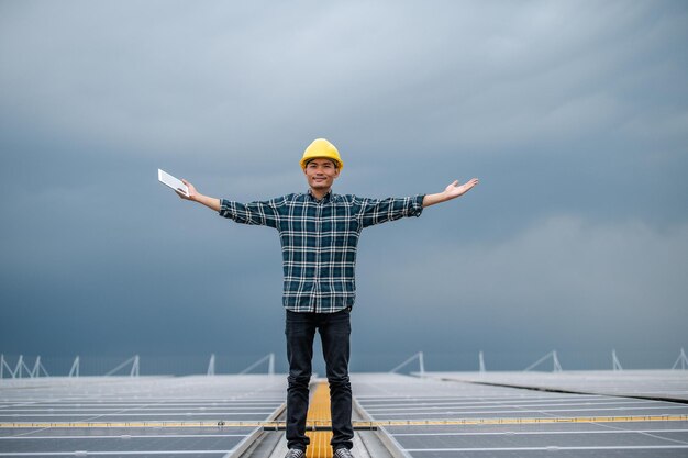 Foto ingegnere asiatico utilizzare tablet ispezione di lavoro installazione cella solare sul tetto manutenzione tecnica celle solari sul tetto fabbrica sotto la luce solare del mattino tecnologia energia solare rinnovabile