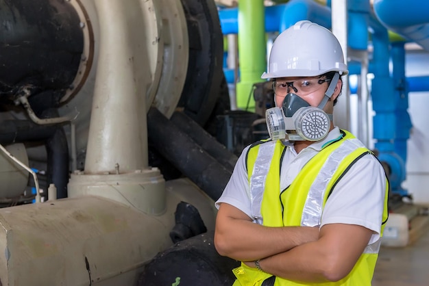 Asian engineer wearing glasses working in the boiler roommaintenance checking technical data of heating system equipmentThailand people Wearing a gas mask