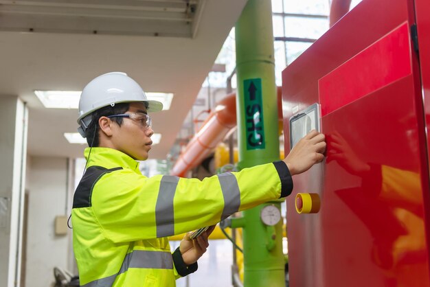 Asian engineer wearing glasses working in the boiler roommaintenance checking technical data of heating system equipmentThailand people