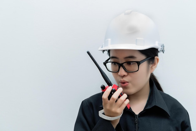 Asian engineer woman wearing glassesusing radio communication on white backgroundthailand technician use walkie talkie for work