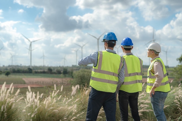 Asian engineer working in fieldwork outdoor Workers check and inspect construction and machine around building project site Wind turbine for electrical of clean energy and environment sustainable