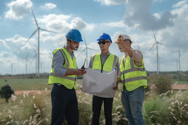 Asian engineer working in fieldwork outdoor Workers check and inspect construction and machine around building project site Wind turbine for electrical of clean energy and environment sustainable