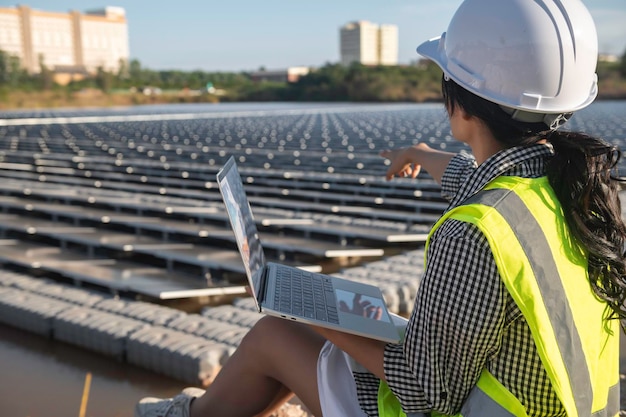 Asian engineer working at floating solar farmrenewable\
energytechnician and investor solar panels checking the panels at\
solar energy installation