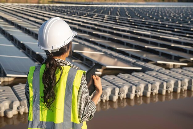 Asian engineer working at Floating solar farmRenewable energyTechnician and investor solar panels checking the panels at solar energy installation