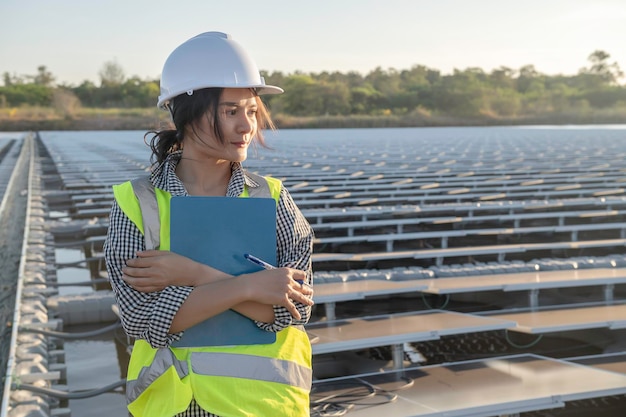 Asian engineer working at floating solar farmrenewable
energytechnician and investor solar panels checking the panels at
solar energy installation