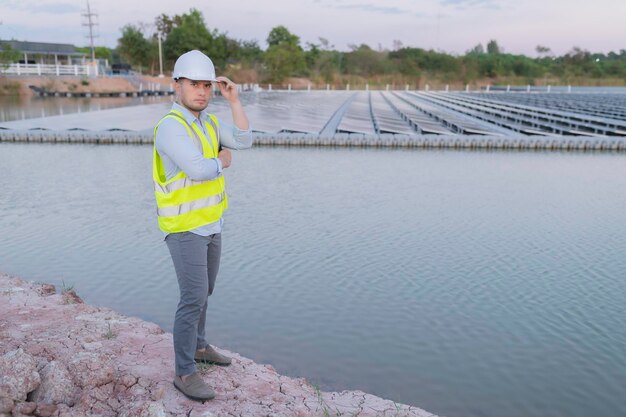 Foto ingegnere asiatico che lavora presso la fattoria solare galleggianteenergia rinnovabiletecnico e investitore di pannelli solari che controllano i pannelli nell'installazione di energia solare