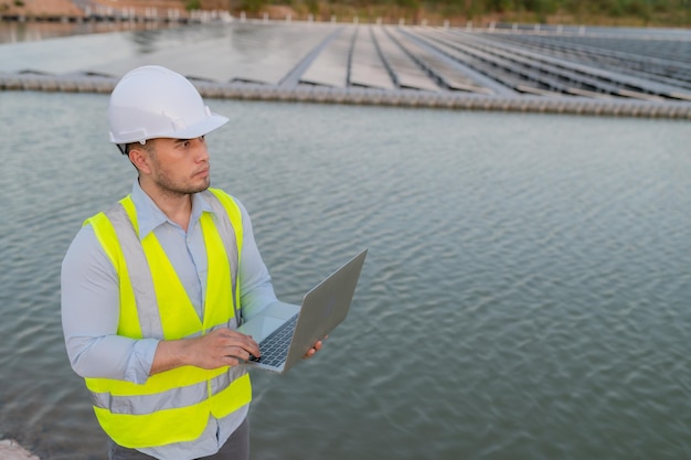 Foto ingegnere asiatico che lavora presso la fattoria solare galleggianteenergia rinnovabiletecnico e investitore di pannelli solari che controllano i pannelli nell'installazione di energia solare