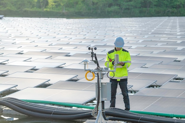 水上太陽光発電所で働くアジアのエンジニア再生可能エネルギー技術者と投資家のソーラー パネルは、太陽エネルギーのインストールでパネルをチェックします。