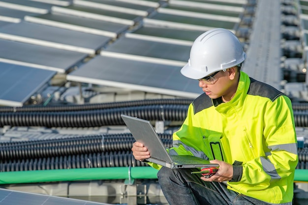 Asian engineer working at floating solar power plantrenewable\
energytechnician and investor solar panels checking the panels at\
solar energy installation