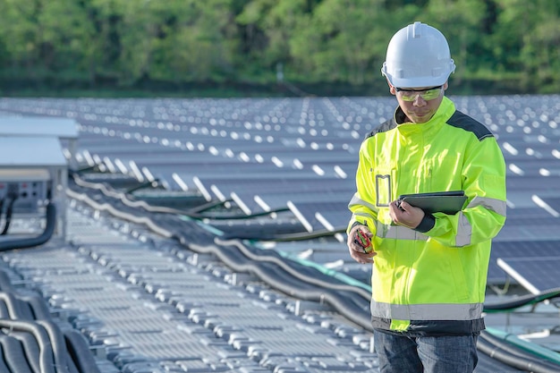 水上太陽光発電所で働くアジアのエンジニア再生可能エネルギー技術者と投資家のソーラー パネルは、太陽エネルギーのインストールでパネルをチェックします。