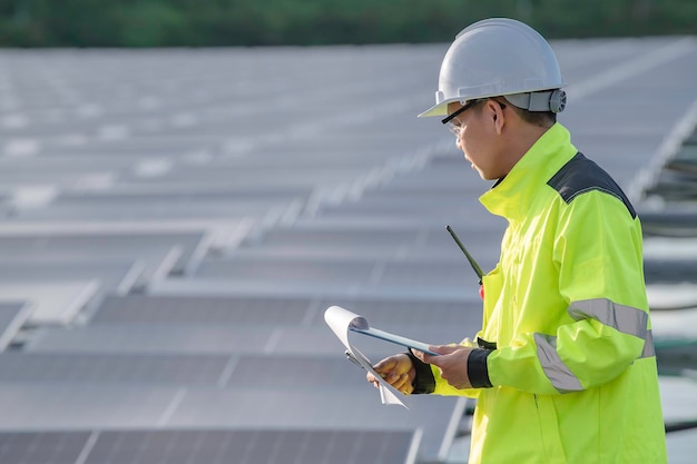 水上太陽光発電所で働くアジアのエンジニア再生可能エネルギー技術者と投資家のソーラー パネルは、太陽エネルギーのインストールでパネルをチェックします。