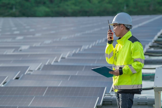 水上太陽光発電所で働くアジアのエンジニア再生可能エネルギー技術者と投資家のソーラー パネルは、太陽エネルギーのインストールでパネルをチェックします。