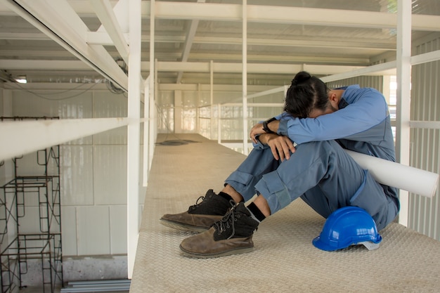 Asian engineers suffering stress fail to make mistakes in their work sit down on the floor