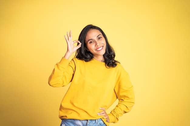 Asian ethnicity female looking at camera smiling with fun gesture