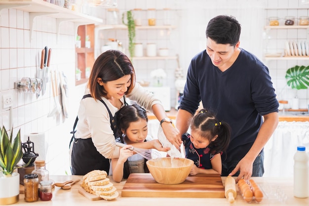 Asian family enjoy playing and cooking food in kitchen at home